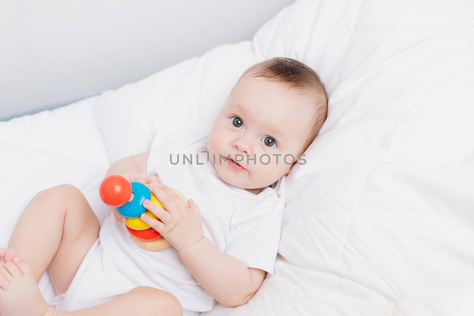 A kid with a wooden pyramid . Happy baby. Children's toys. Wooden toys