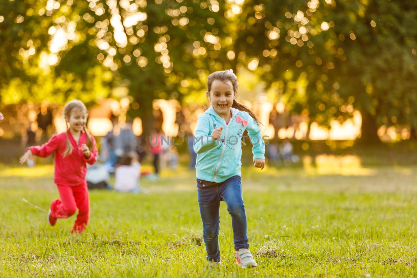 Adorable little girls having fun playing outdoors on summer day by Andelov13