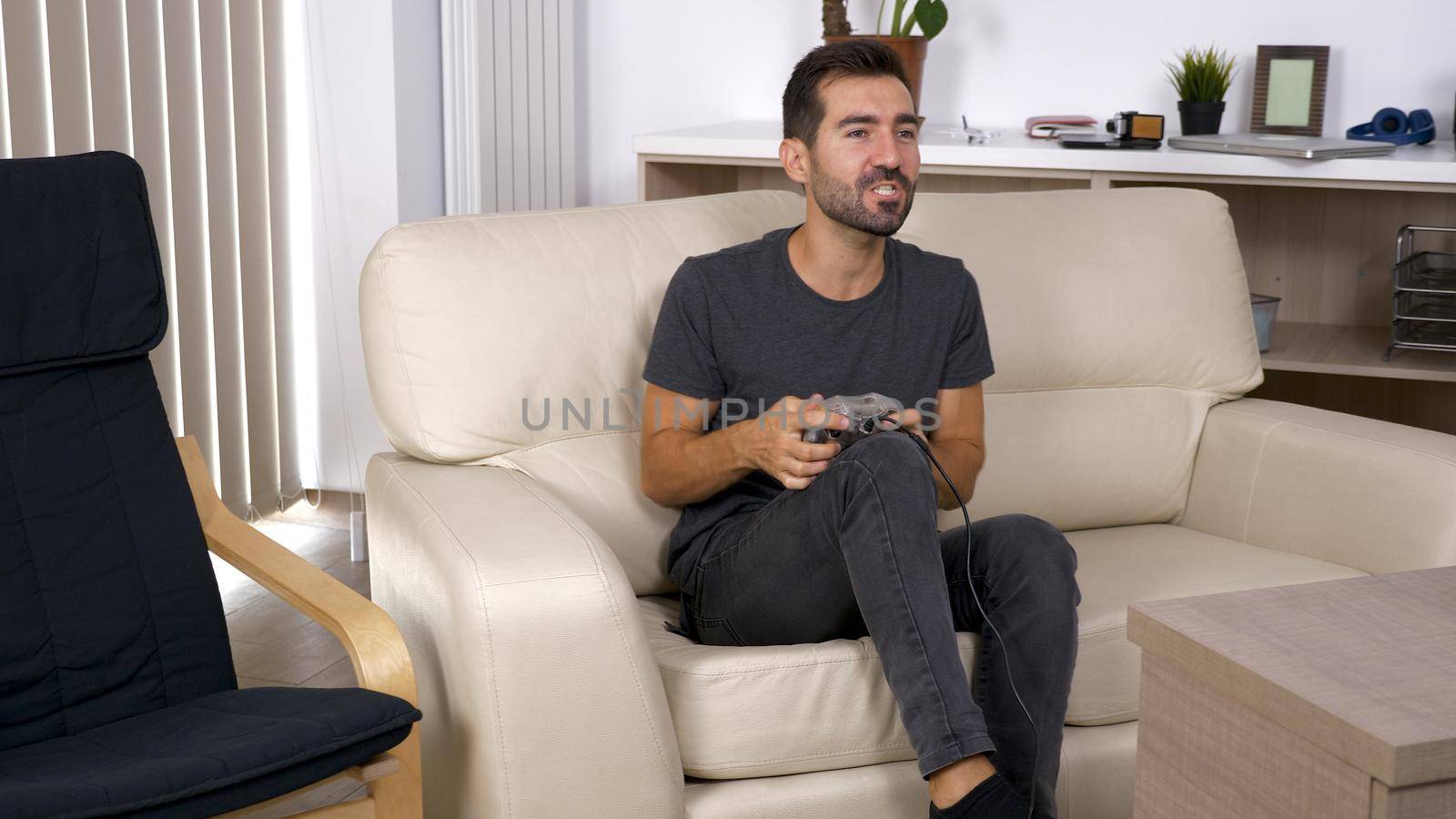 Young man playing video games at home. Elated man about his video games.