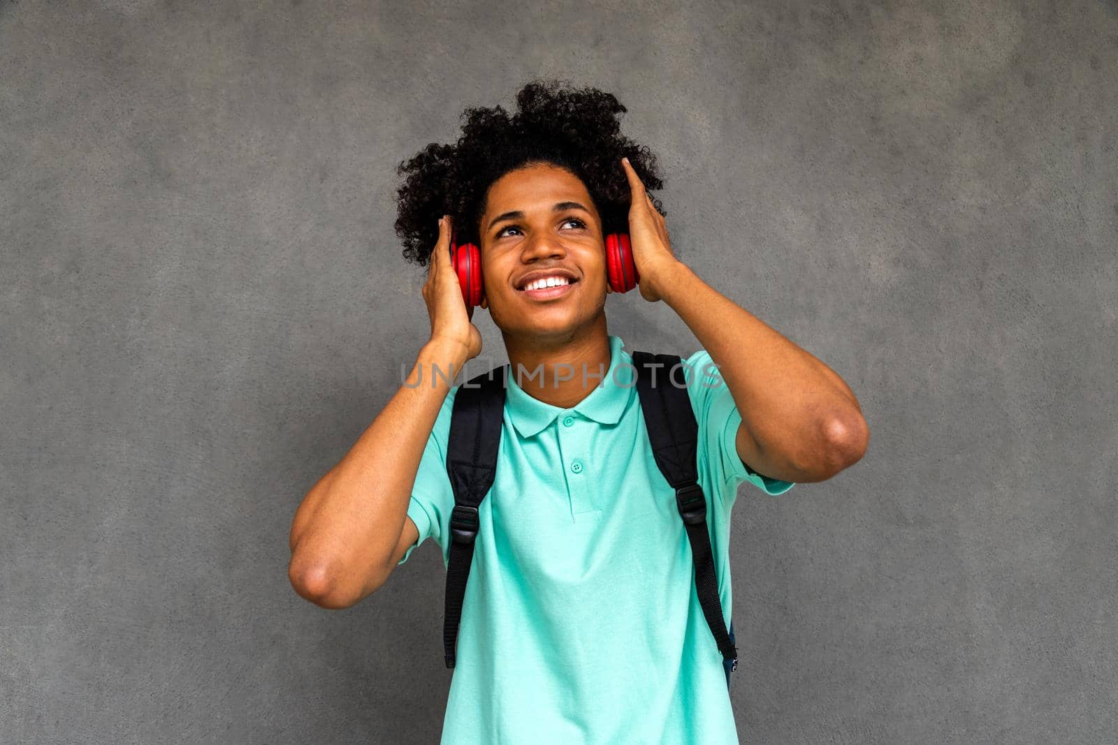 African American male teenager listens to music with headphones. Lifestyle concept.