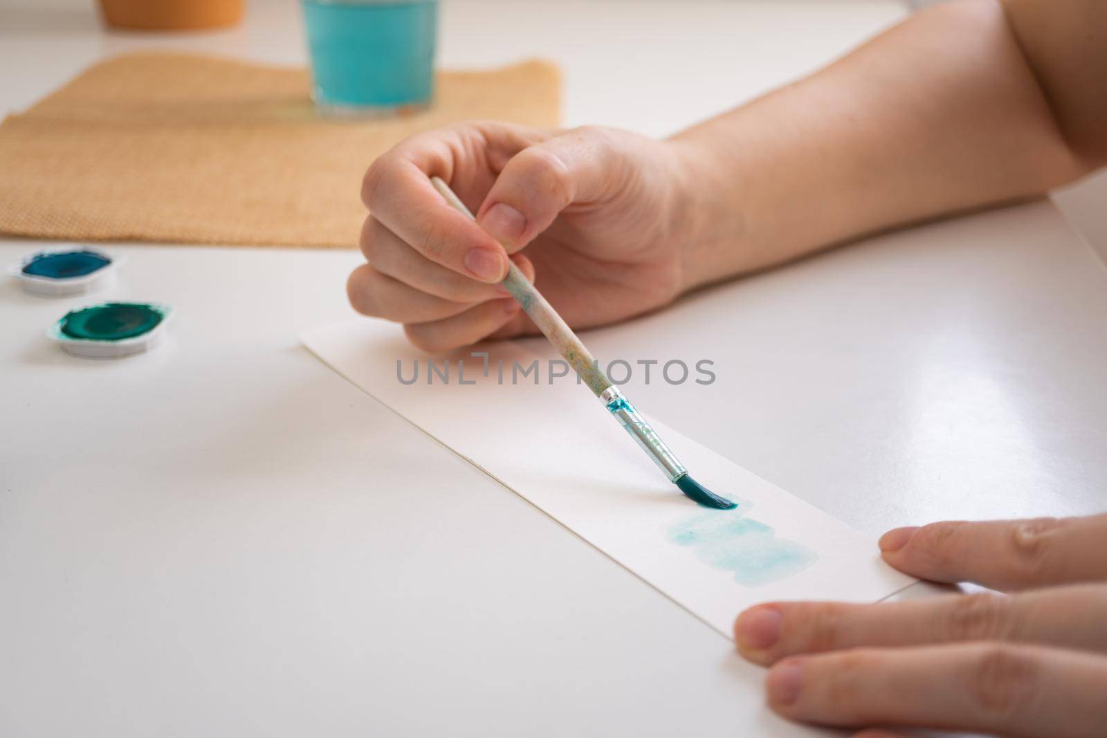 woman painting with watercolors in her studio at home