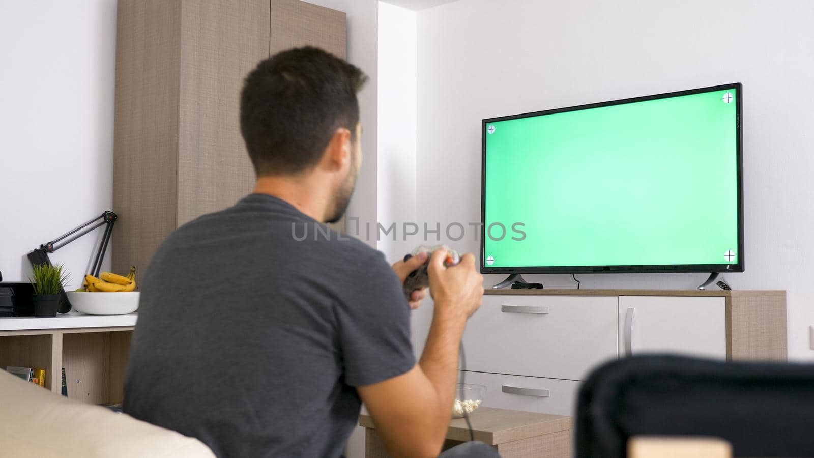 Man playing with joystick while sitting in his couch. Relaxing time