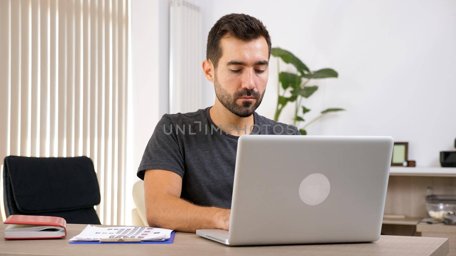 Young man working with laptop at his business documentation . Business person at workplace.