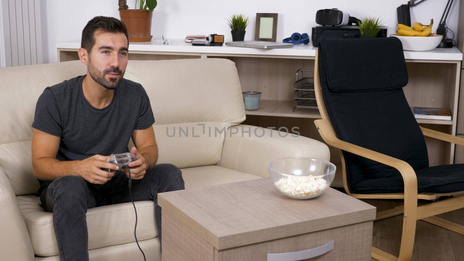 Young man playing video games at home. Elated man about his video games.