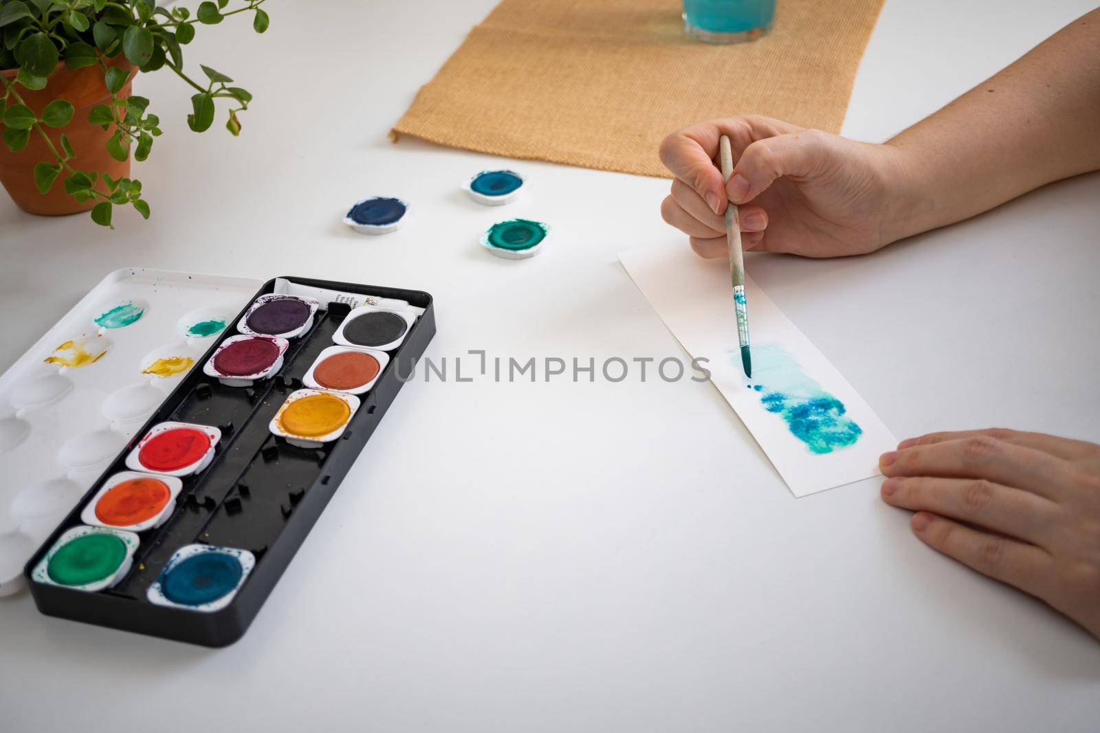 woman painting with watercolors in her studio at home