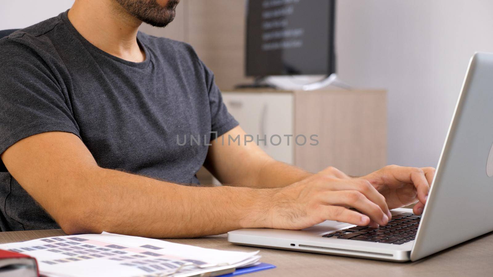 Young man working with laptop at his business documentation . Business person at workplace.