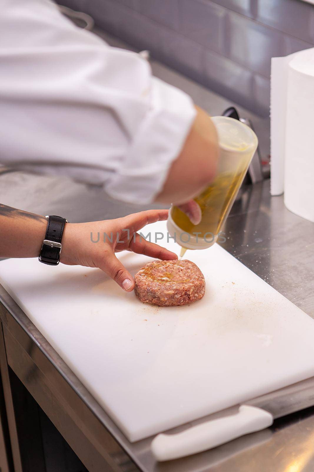 Chef seasoning burger meat in luxury restaurant kitchen