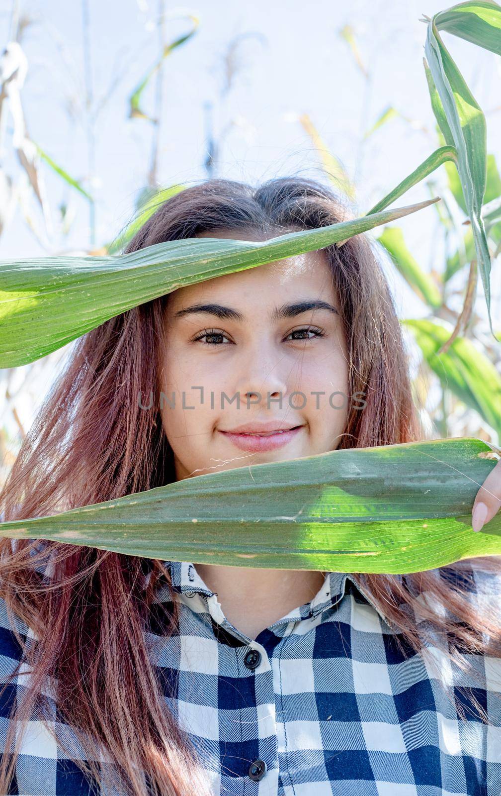 agriculture and cultivation concept. Countryside. closeup shot of caucasian woman covering face with corn leaves