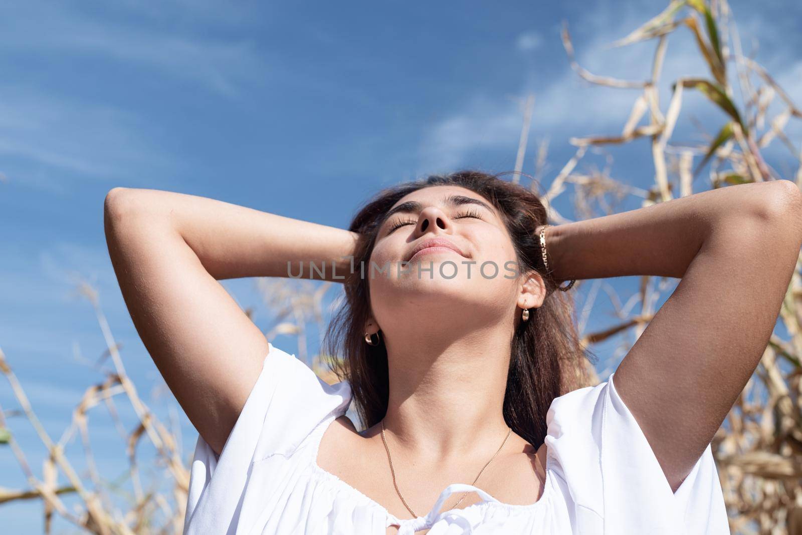agriculture and cultivation concept. Countryside. Cheerful caucasian woman in white dress in the corn crop, sky background