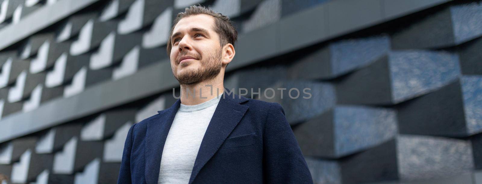 close-up portrait of a serious businessman against the background of the texture wall of the building.