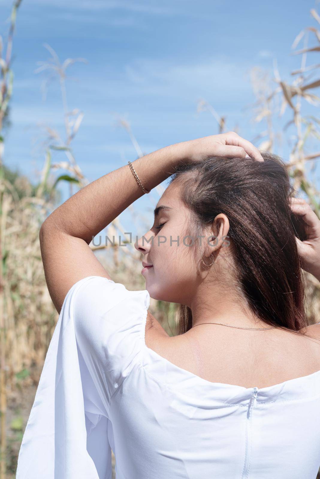 agriculture and cultivation concept. Countryside. Cheerful caucasian woman in white dress in the corn crop, sky background