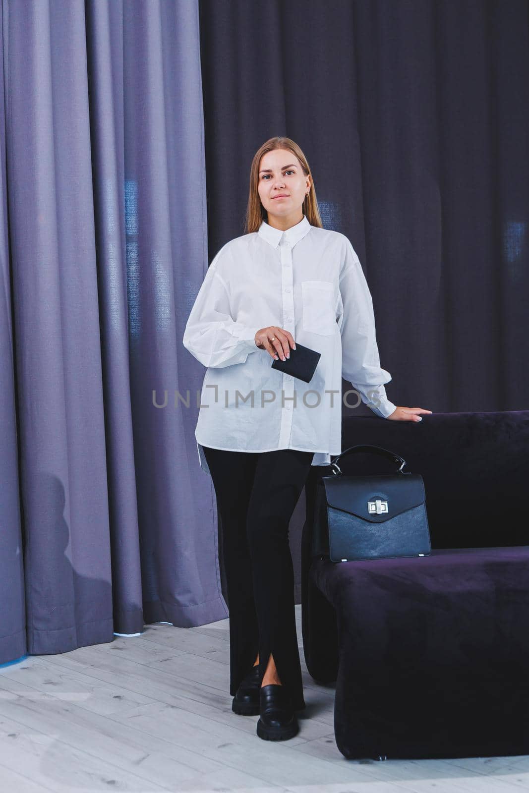 Black classic leather bag in a girl's hand. Woman with luxury bag.