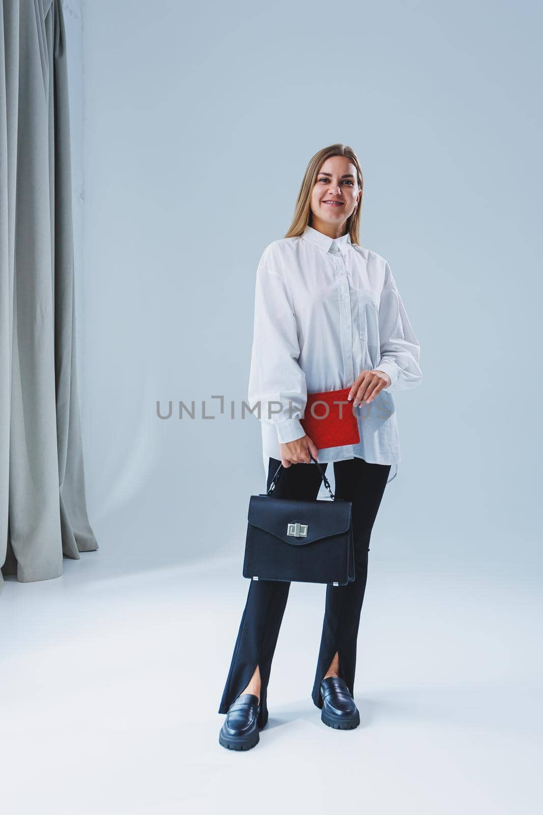 Black classic leather bag in a girl's hand. Woman with luxury bag.