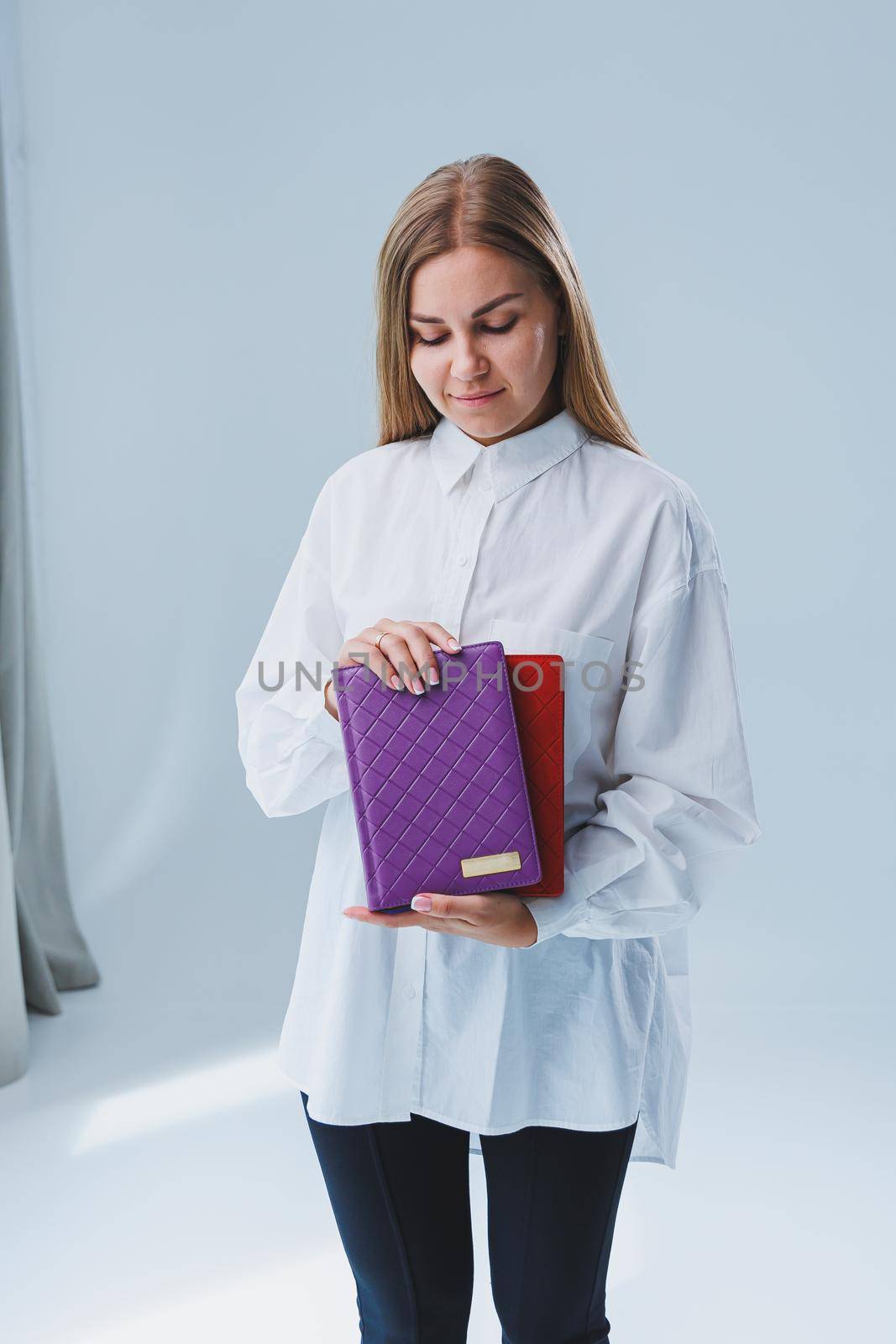A stylish woman holds a notebook in her hands. Notebook for business records.
