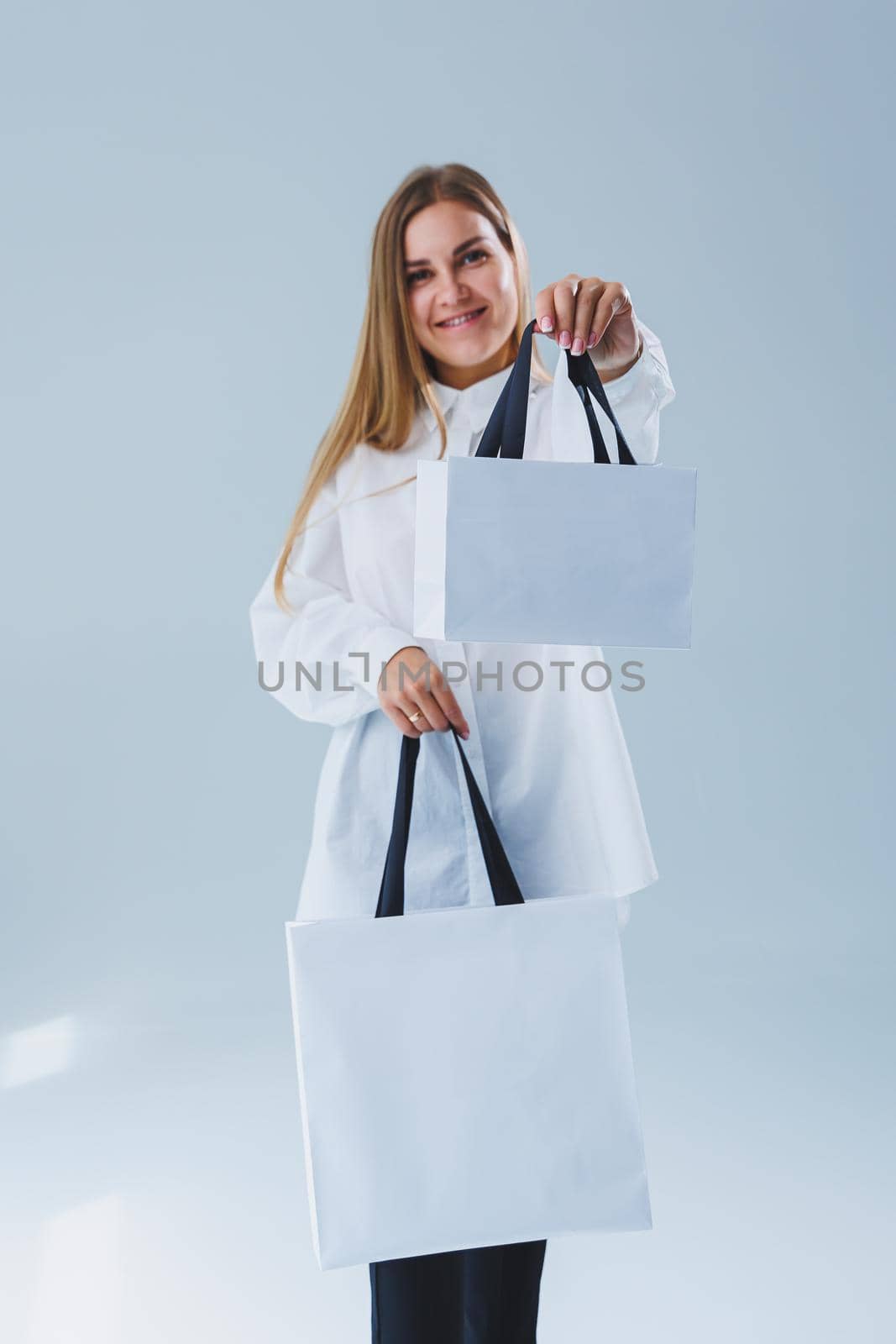 Stylish woman on a white background with a shopping bag. Eco bag for shopping.