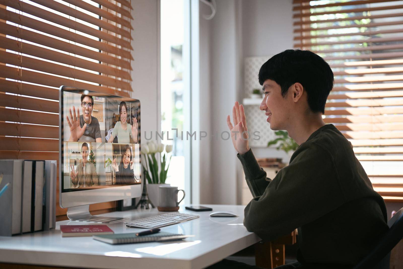 Smiling asian man making video call with colleagues during working from home. People and communication concept.