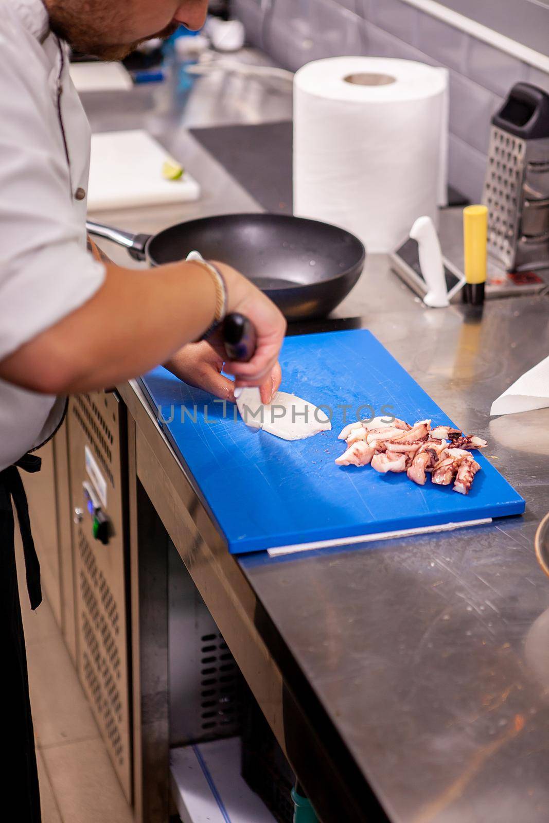 Male cook slicing seafood in restaurant kitchen.Delicious food