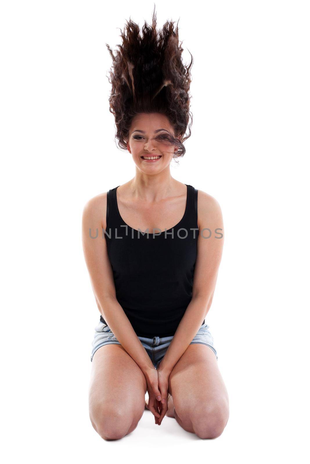 Yong woman sit on white and smile - curly hair up isolated