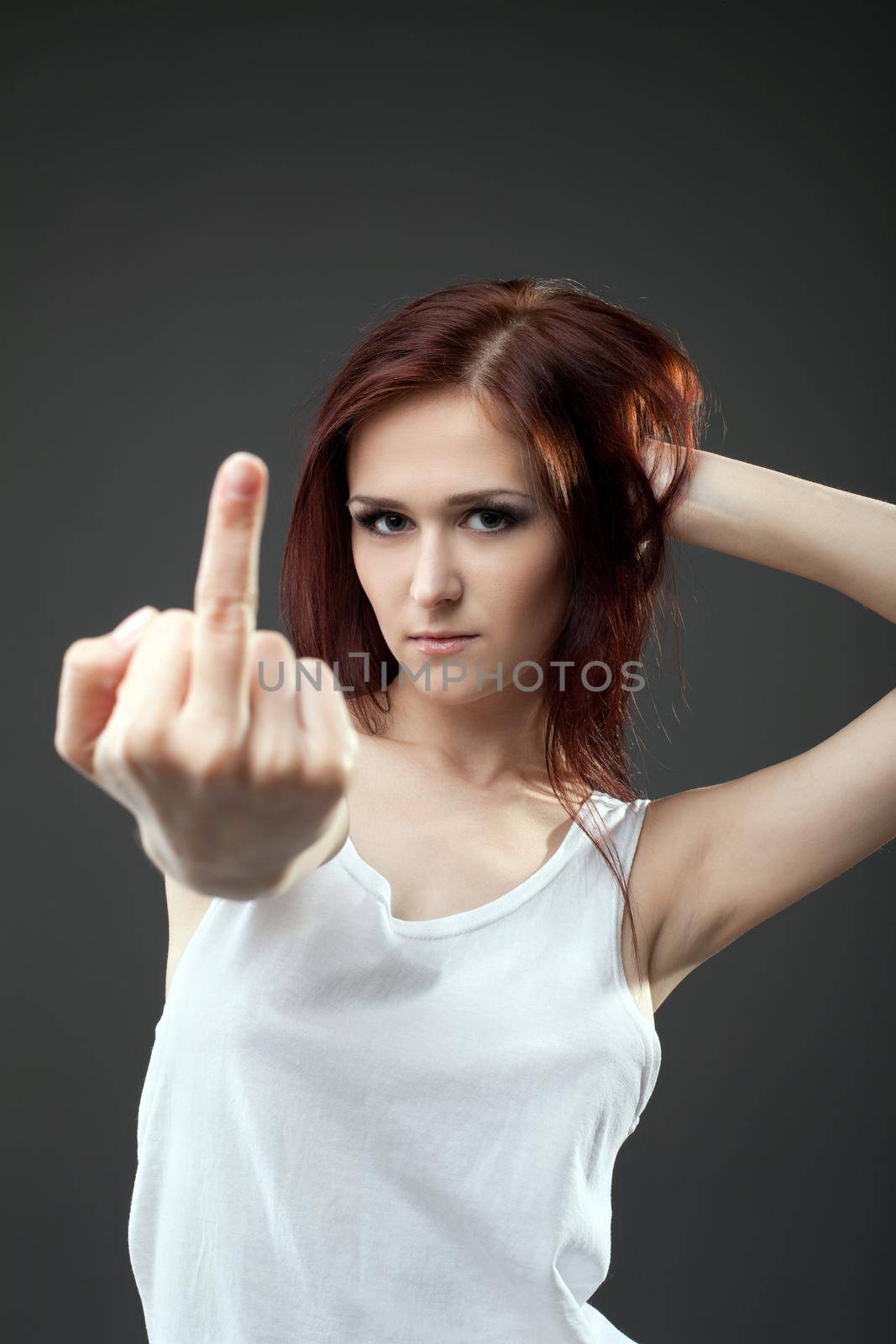 Anger young woman in tank top with fuck sign expressive portrait