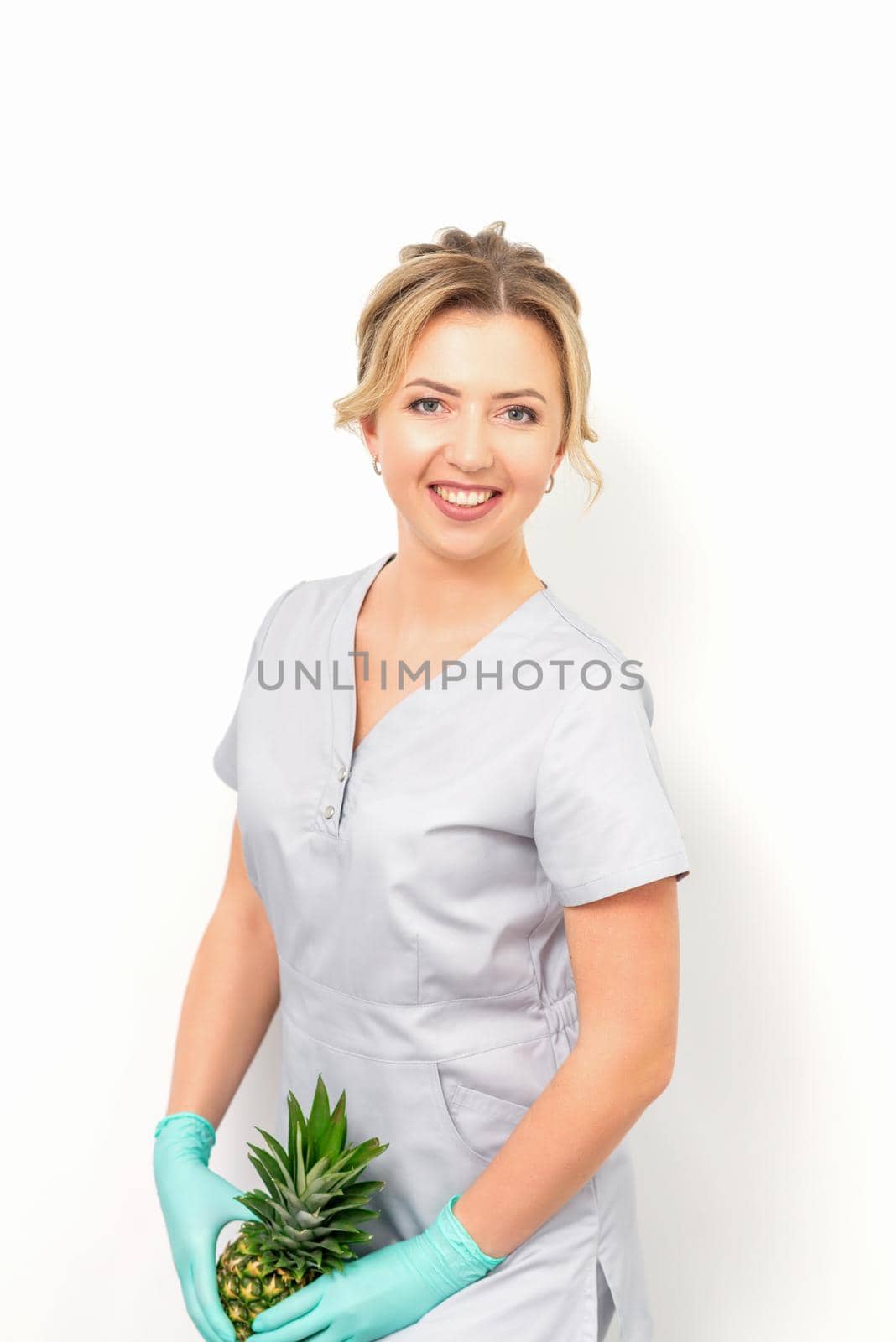 Female doctor beautician with pineapple. Concept of epilation or depilation and intimate hygiene