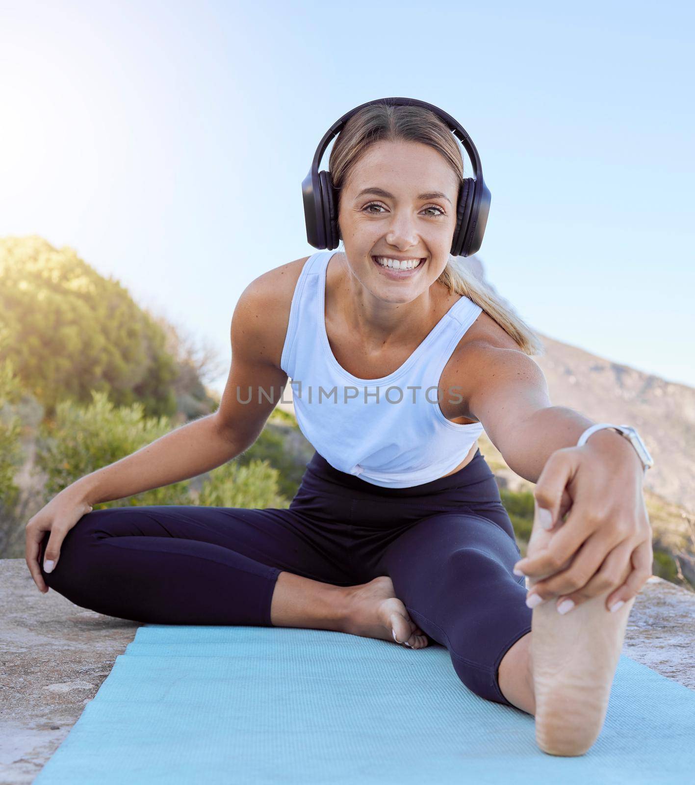 Workout yoga stretch, music streaming headphones and woman outdoor on a mat. Portrait of a happy smile from female wellness, exercise and healthy stretching before training in nature on a mountain.