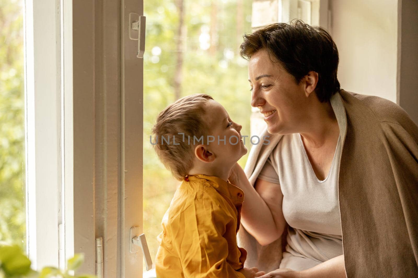 Happy grandmother and grandson enjoy time together. Positive middle age woman spending time with little, cute grandchild. 50-year-old grandma with grandkid. Multi-generational family