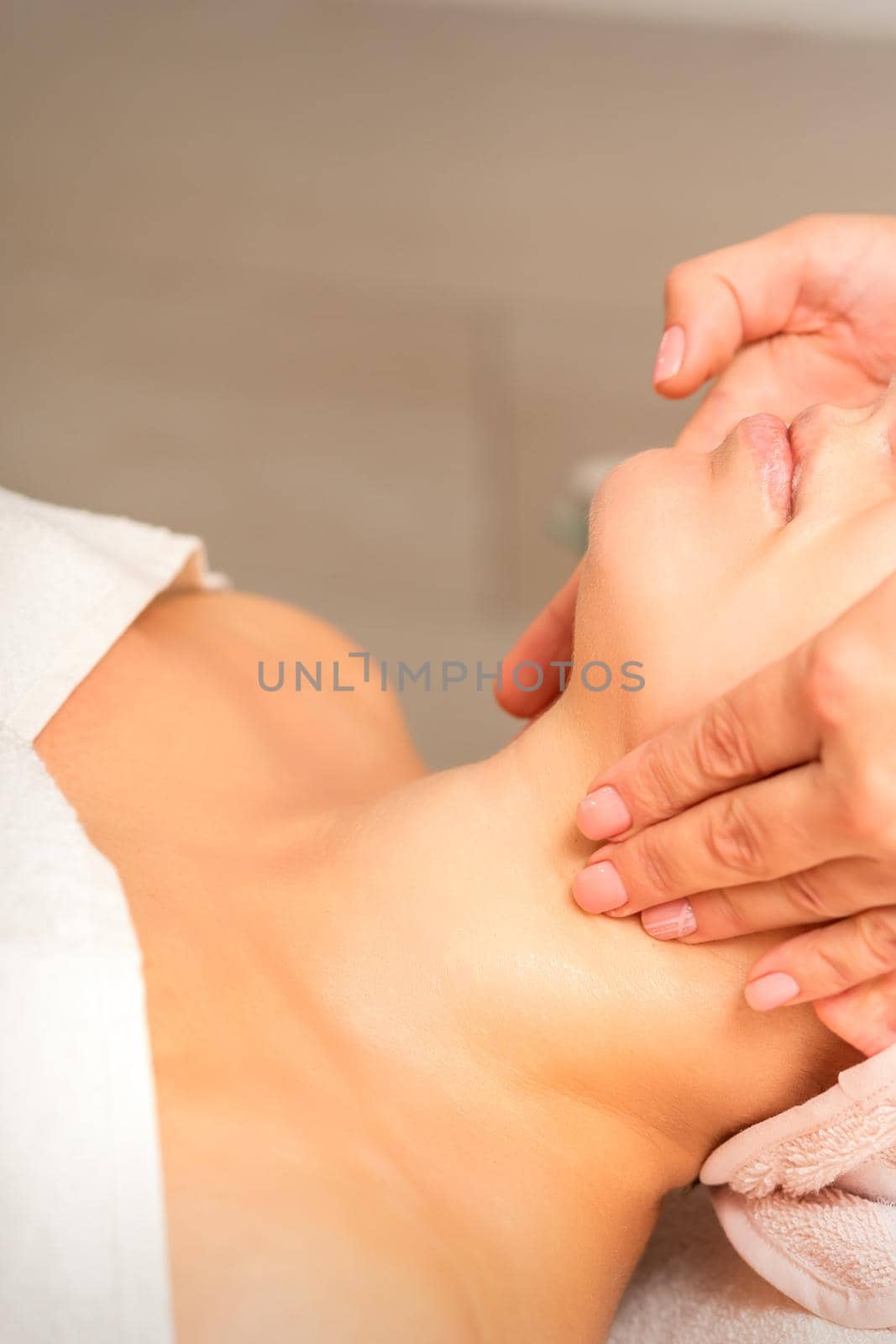 Facial massage. Young caucasian woman getting a massage on her neck in a beauty clinic