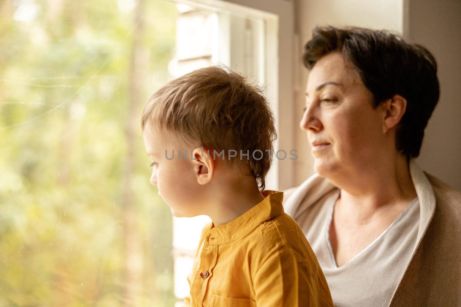Happy grandmother and grandson enjoy time together. Positive middle age woman spending time with little, cute grandchild. 50-year-old grandma with grandkid. Multi-generational family. by creativebird
