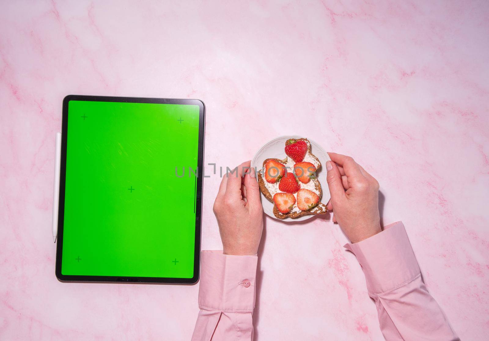 woman holding soft cheese and strawberry sandwich near green screen tablet, concept of healthy food and diet, using calorie counting app, top view, High quality photo