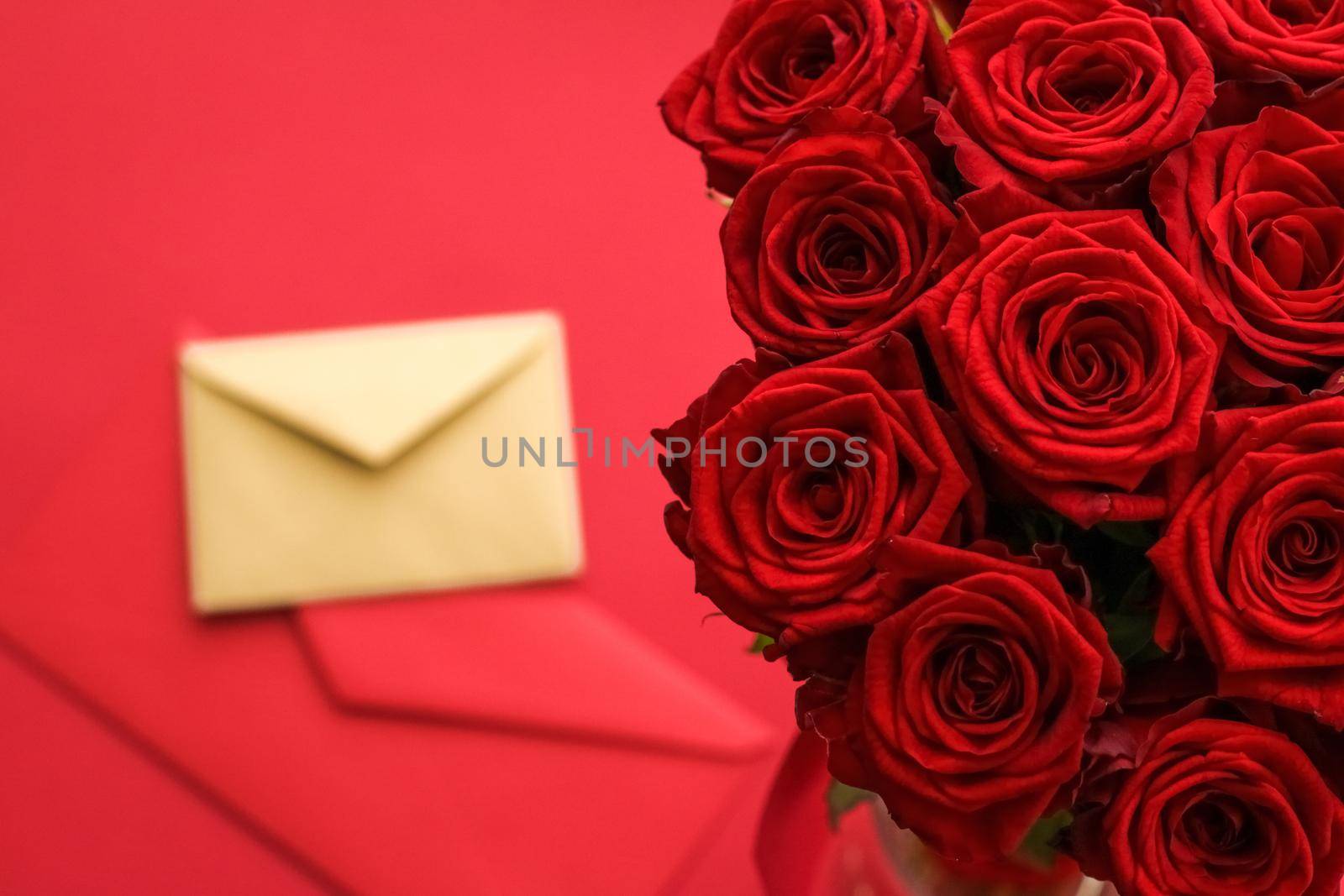 Holiday gift, flowers flatlay and happy relationship concept - Love letter and flower delivery service on Valentines Day, luxury bouquet of red roses and card envelopes on red background