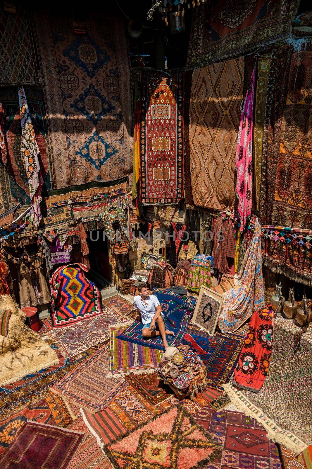 young man at an old traditional Turkish carpet shop in cave house Cappadocia, Turkey Kapadokya by fokkebok