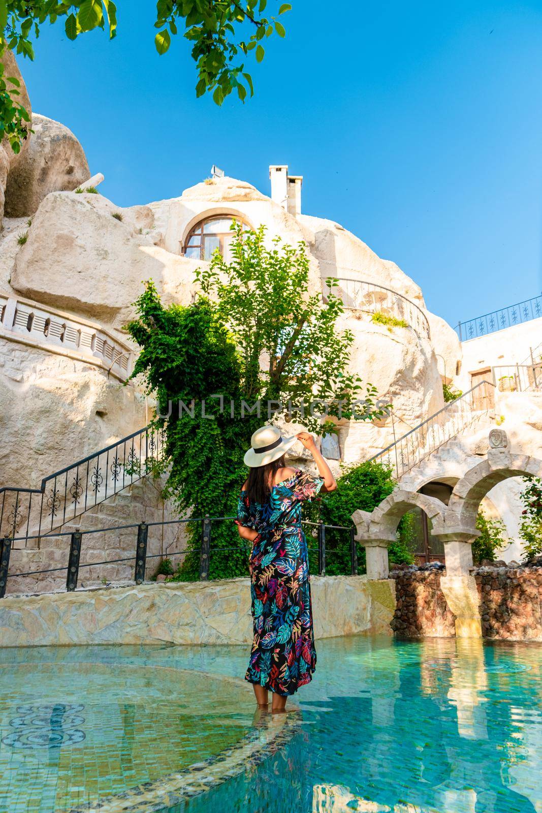 woman in dress at cave house, woman infinity pool cave house hotel in the mountains of Cappadocia.