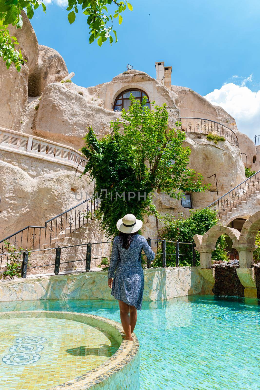 woman in dress at cave house, woman infinity pool cave house hotel in the mountains of Cappadocia.