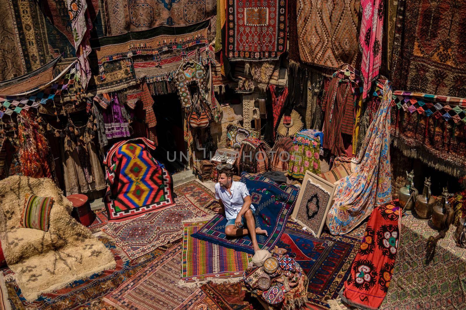 young man at an old traditional Turkish carpet shop in cave house Cappadocia, Turkey Kapadokya by fokkebok