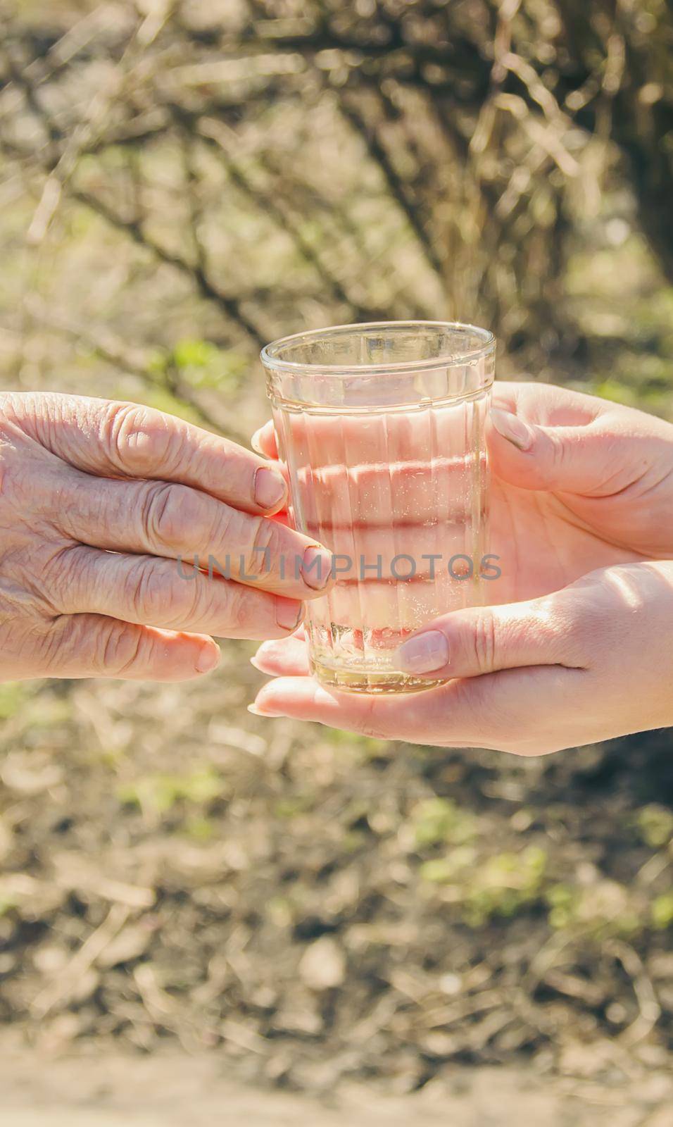 Grandmother giving a glass of clean water to a child. Selective focus. food.