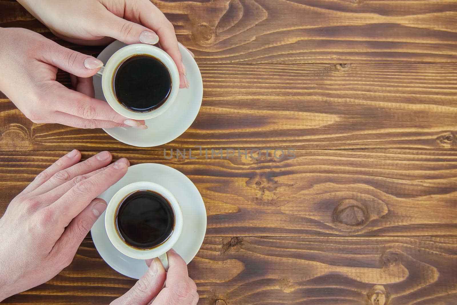 Cups with a coffee in the hands of men and women.