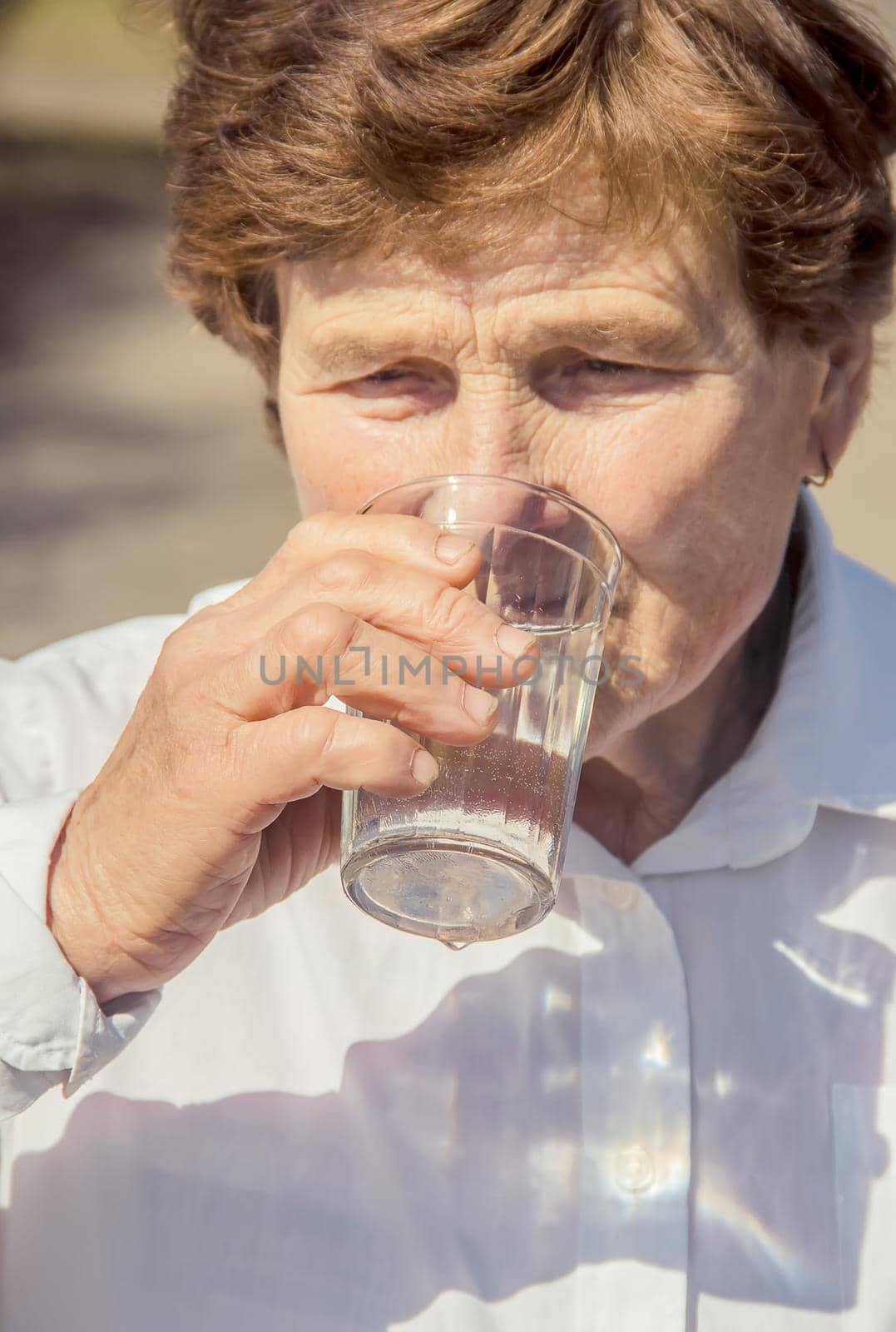 Grandmother giving a glass of clean water to a child. Selective focus.
