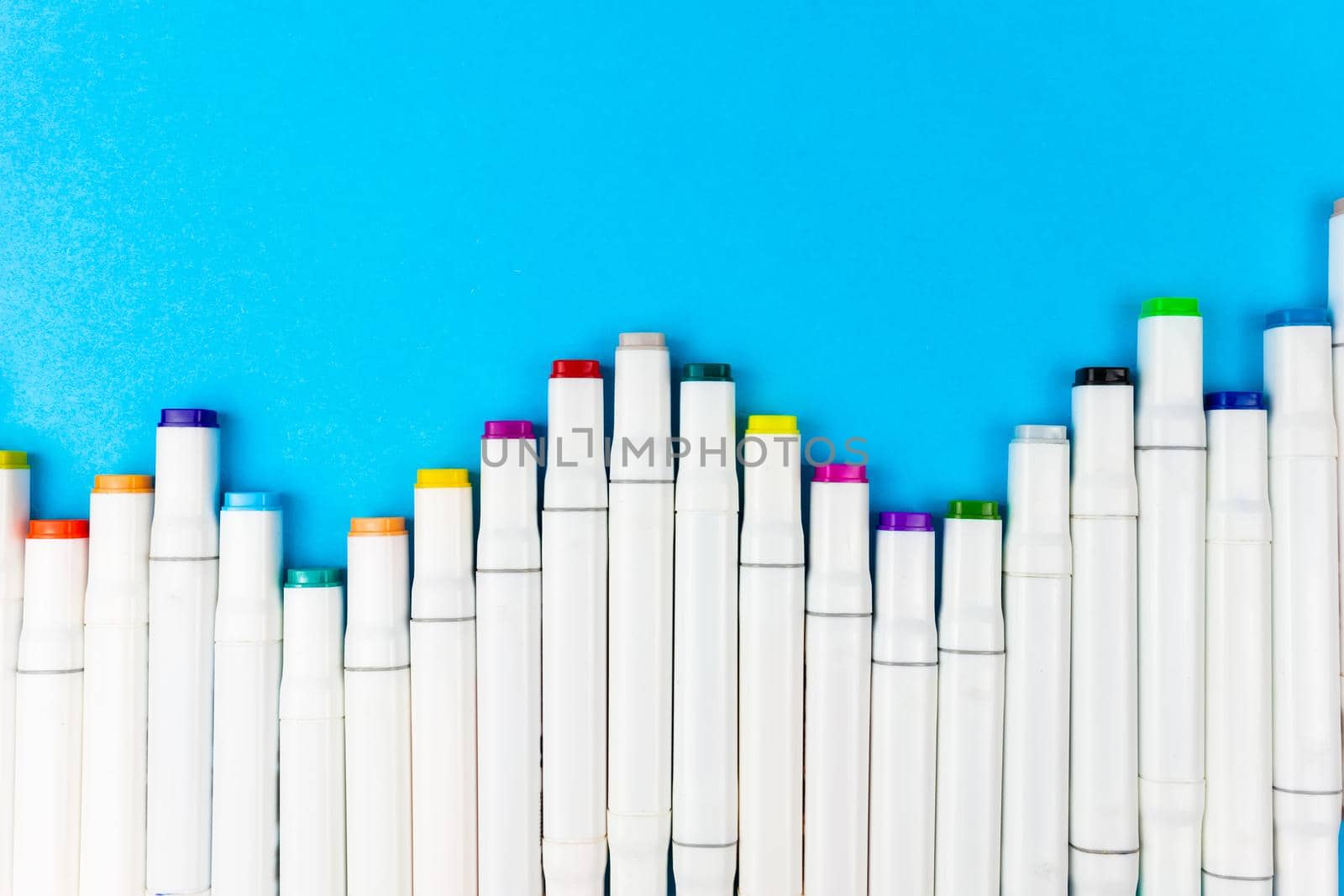 Many colorful white markers lie on a blue background