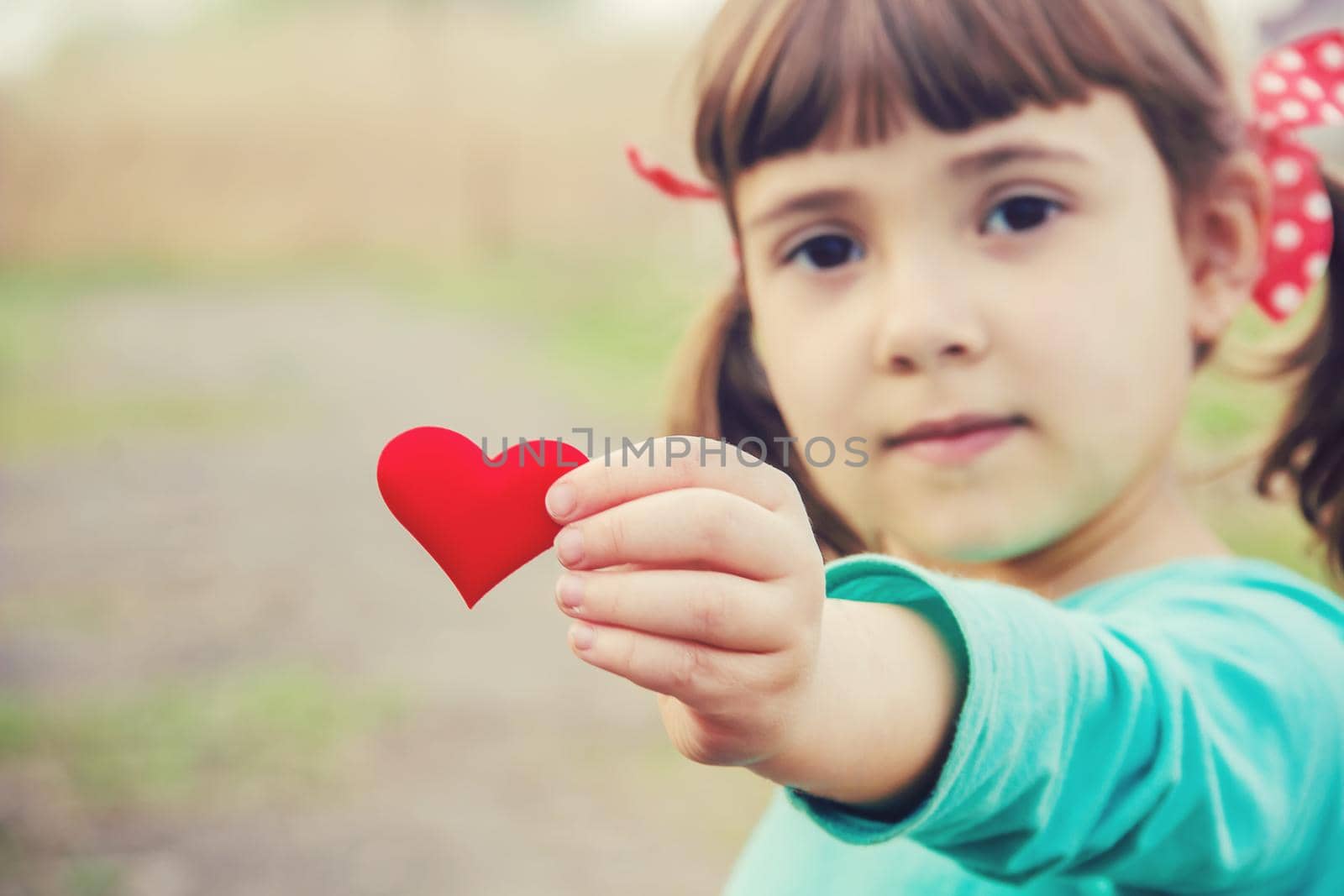 The heart is in the hands of the child. Selective focus.