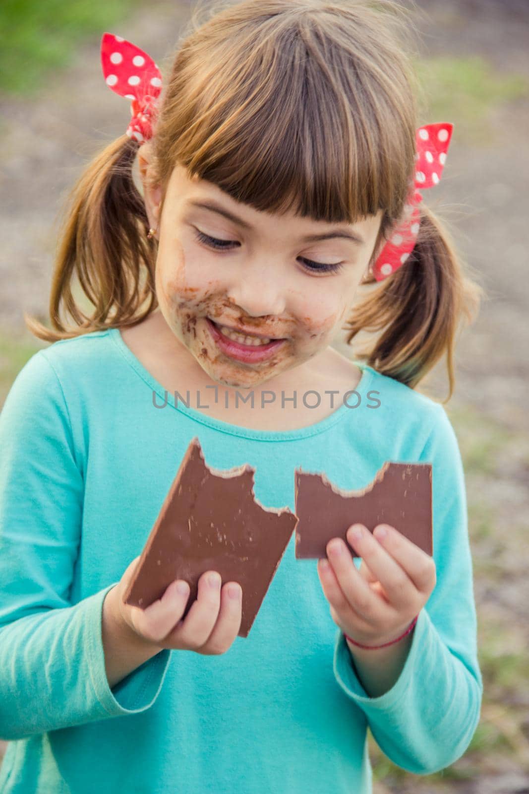 A sweet-toothed child eats chocolate. Selective focus. by yanadjana
