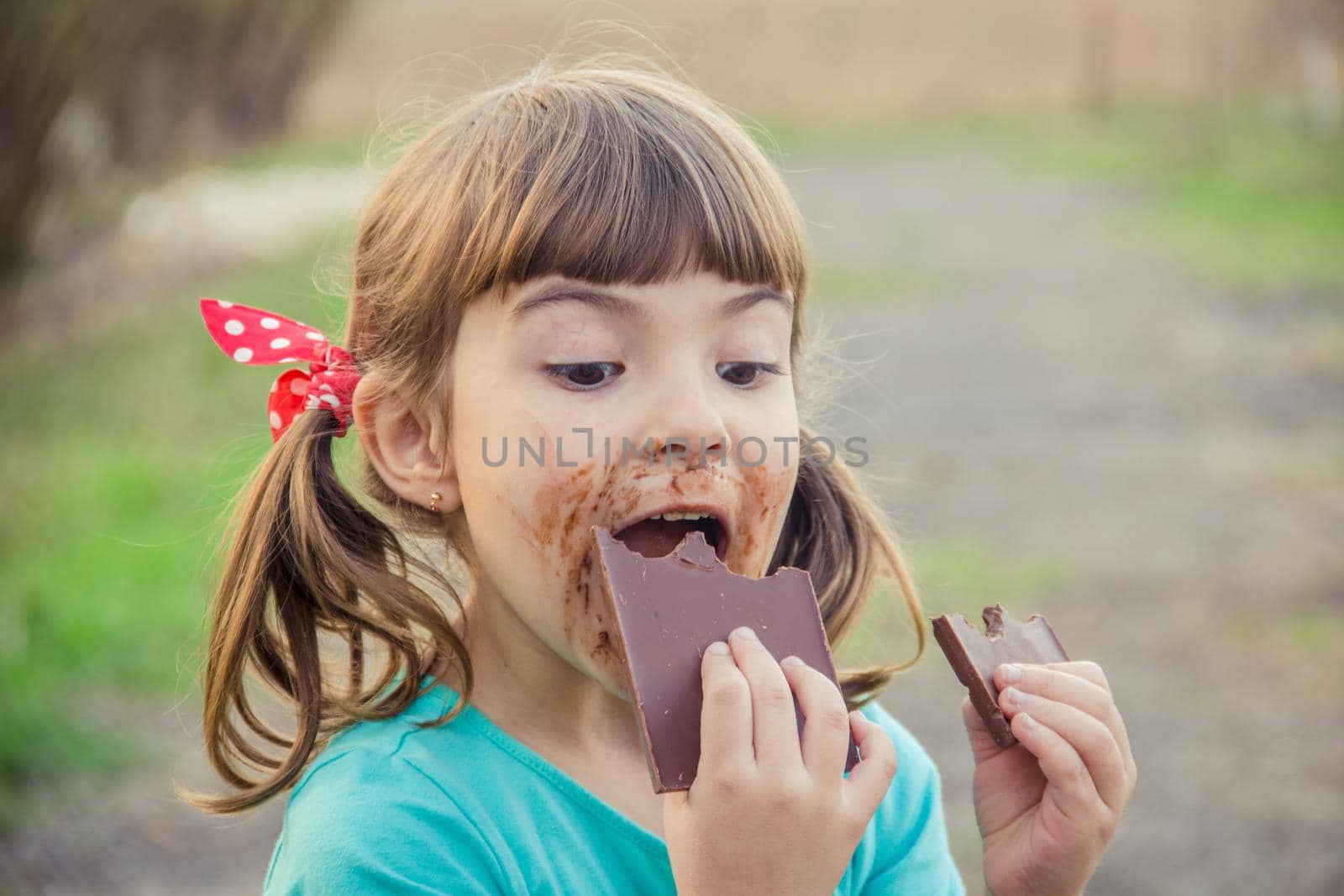 A sweet-toothed child eats chocolate. Selective focus.