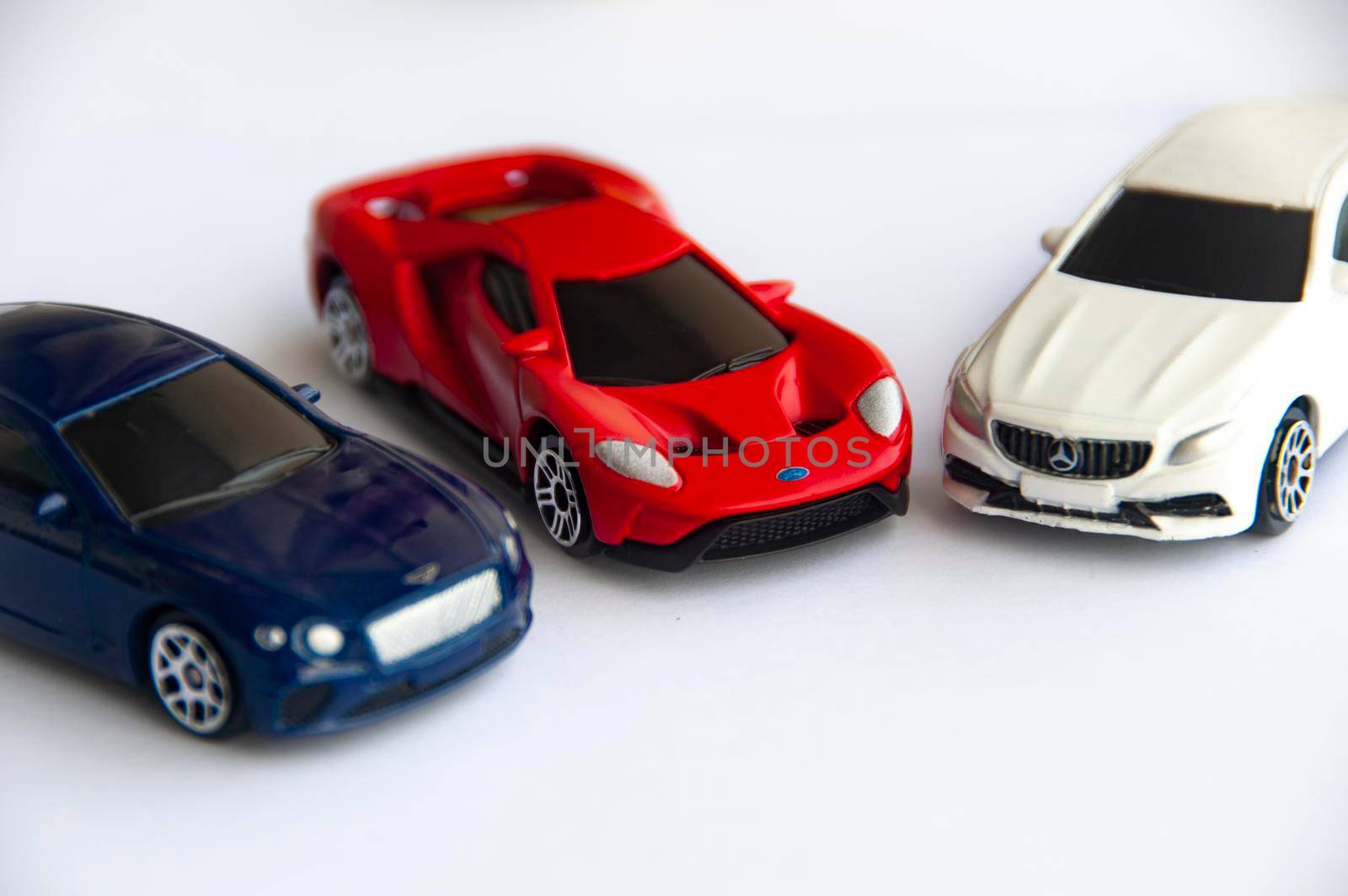Kuala Lumpur, Malaysia - September 2022 : Miniature toy car of Bentley Continental GT, Ford GT and Mercedes AMG with gold on white background. Copy space