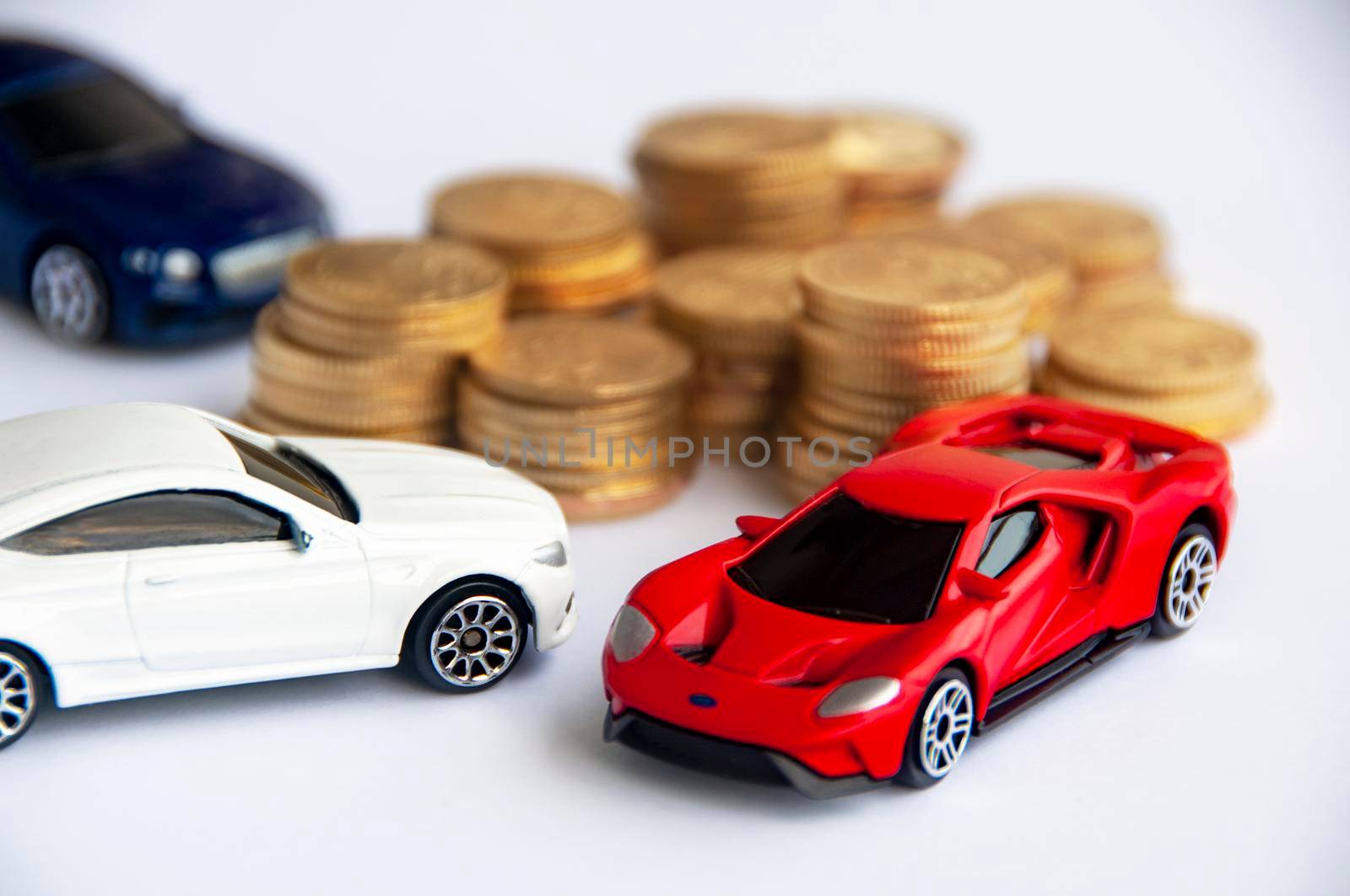 Kuala Lumpur, Malaysia - September 2022 : Miniature toy car of Mercedes AMG, Ford Gt and Bentley Continental GT with blurred gold coin background. Copy space