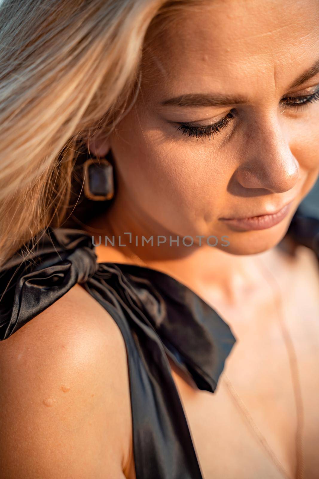 Blonde long hair, nature summer happy adult girl with long blond hair developing in the wind in nature. Dressed in a black top, white skirt. by Matiunina