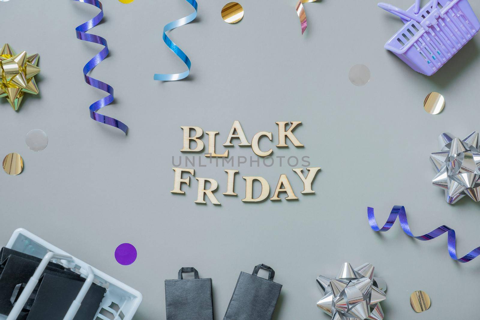 Black friday text with gifts, shopping baskets and festive tinsel flat lay by ssvimaliss