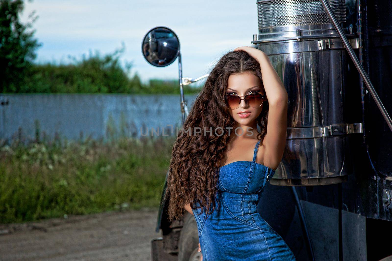 Sexy brunette woman in denim dress and truck
