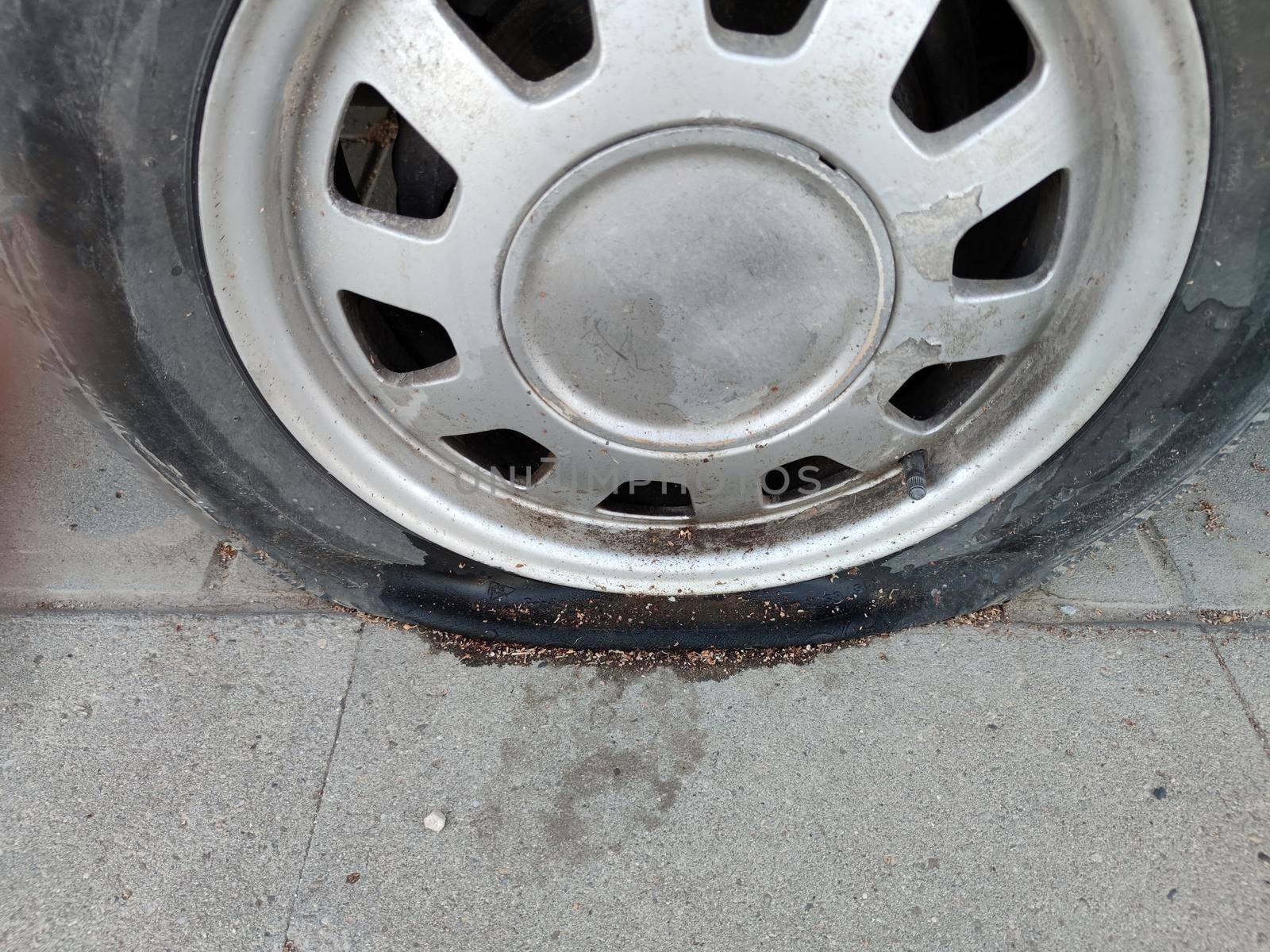 flat punctured car wheel after an accident close-up by Annado