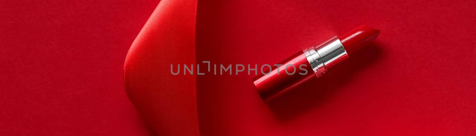 Cosmetic branding, glamour lip gloss and shopping sale concept - Luxury lipstick and silk ribbon on red holiday background, make-up and cosmetics flatlay for beauty brand product design