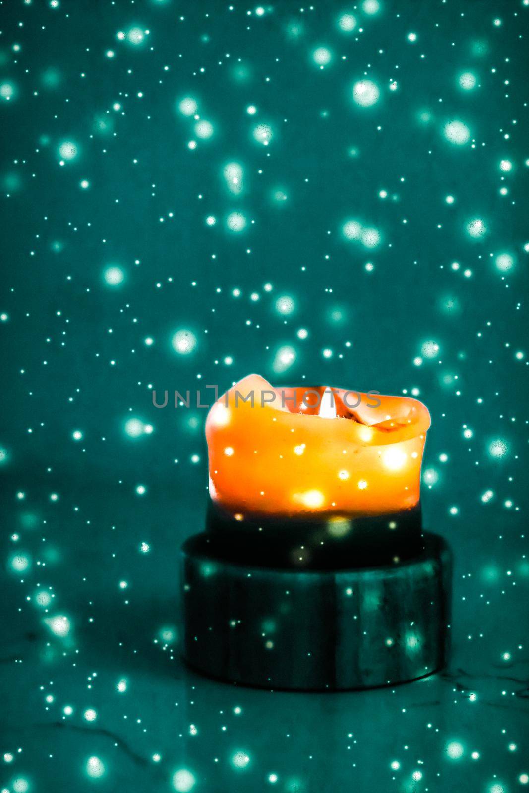 Happy holidays, greeting card and winter season concept - Orange holiday candle on green sparkling snowing background, luxury branding design for Halloween, New Years Eve and Christmas