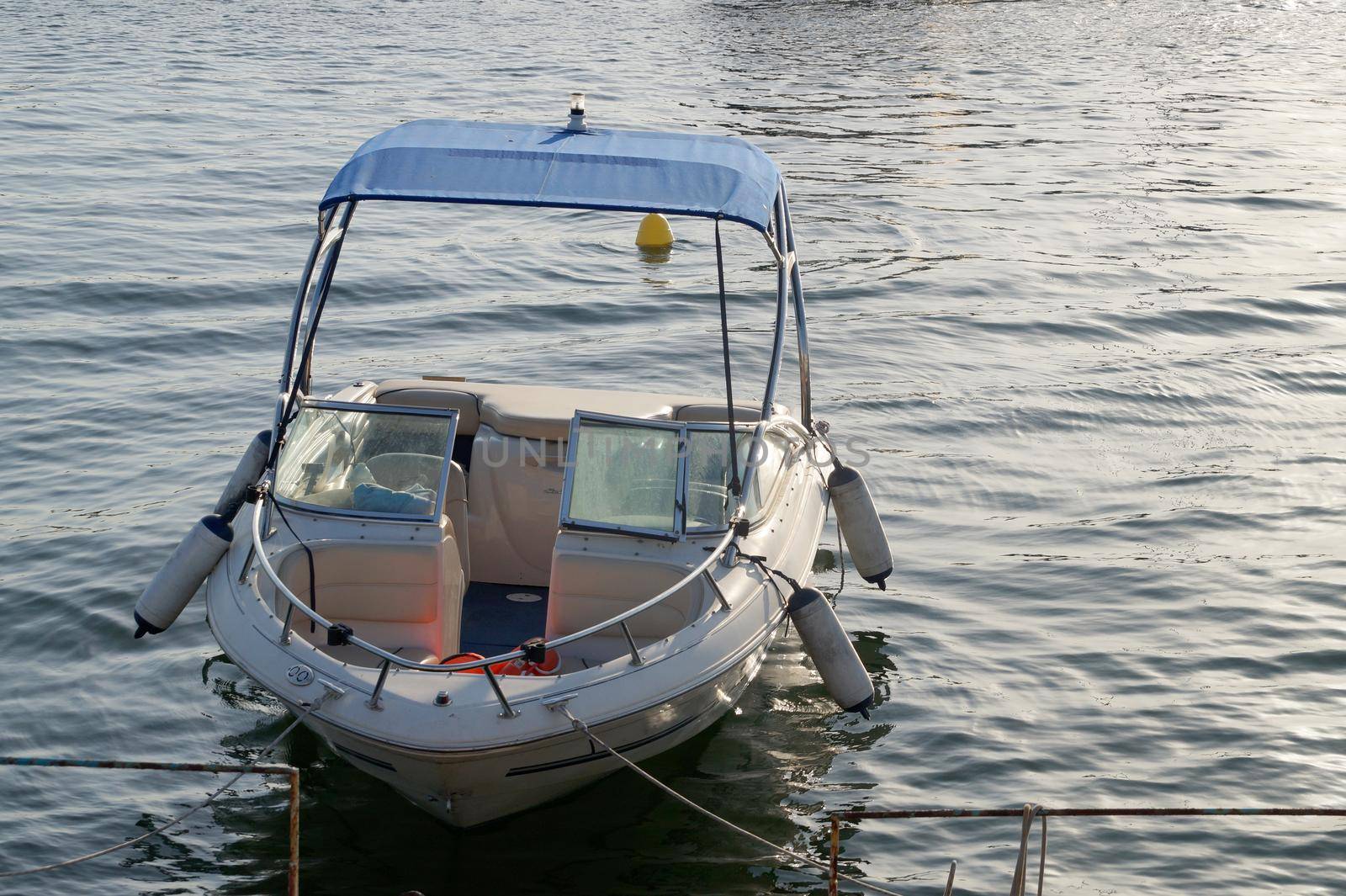 moored empty boat on the pier on the water by Annado